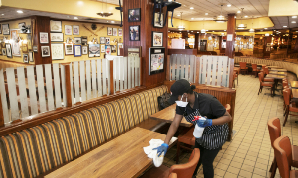 ▲미국 뉴욕의 한 식당 직원이 테이블을 정리하고 있다. 뉴욕(미국)/AP뉴시스