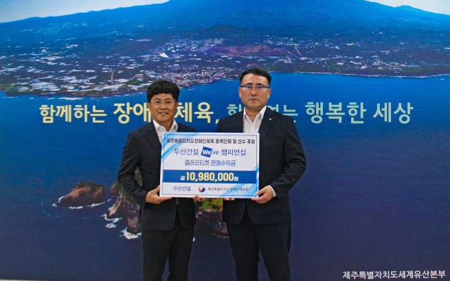 ▲왼쪽부터 오세욱 두산건설 상무와 정재훈 제주특별자치도 장애인체육회 상임부회장이 '두산건설 We've 챔피언십' 갤러리 티켓 판매수익금 전달식에서 기념 촬영을 하고 있다. (사진제공=두산건설)