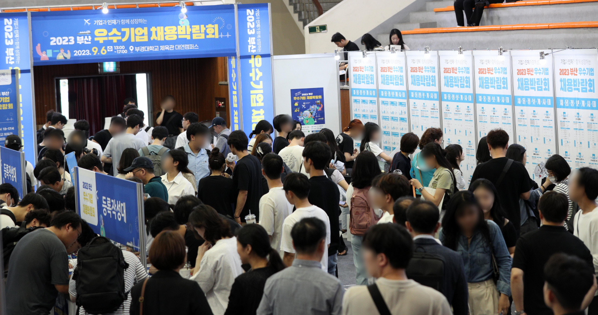 ▲'2023 부산 우수기업 채용박람회'가 열린 6일 부산 남구 부경대 실내체육관에서 구직자들이 채용정보게시대를 살펴보거나 이력서 등을 작성하고 있다. (뉴시스)