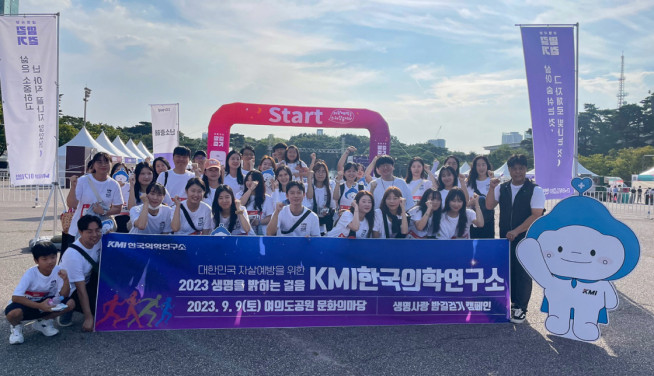 ▲KMI한국의학연구소 임직원과 임직원 가족들이 9일 여의도공원에서 열린 ‘생명사랑 밤길걷기’ 캠페인에 참여해 기념촬영을 하고 있다. (사진제공=KMI한국의학연구소)