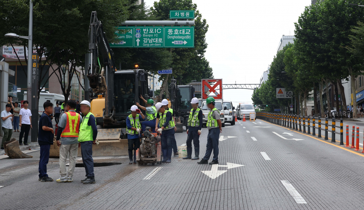 ▲12일 서울 강남구 봉은사로 한복판에서 지름 1m, 깊이 3m 가량 땅꺼짐(싱크홀) 현상이 발생한 가운데 관계자들이 복구작업을 하고 있다. 경찰과 강남구청에 따르면 이날 오전10시 45분께 서울 지하철 9호선 언주역 8번 출구 앞 도로에서 땅꺼짐 현상이 발생했다. 도로를 지나던 사다리차 바퀴가 구멍에 빠졌으나 인명 피해는 발생하지 않았다. 땅꺼짐 현상은 인근 상수도관 파손으로 지반이 약해짐에 따라 발생한 것으로 알려졌다. 신태현 기자 holjjak@