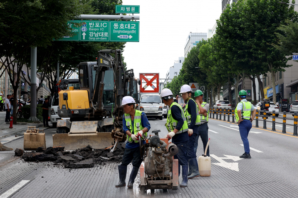 ▲12일 서울 강남구 봉은사로 한복판에서 지름 1m, 깊이 3m 가량 땅꺼짐(싱크홀) 현상이 발생한 가운데 관계자들이 복구작업을 하고 있다. 경찰과 강남구청에 따르면 이날 오전10시 45분께 서울 지하철 9호선 언주역 8번 출구 앞 도로에서 땅꺼짐 현상이 발생했다. 도로를 지나던 사다리차 바퀴가 구멍에 빠졌으나 인명 피해는 발생하지 않았다. 땅꺼짐 현상은 인근 상수도관 파손으로 지반이 약해짐에 따라 발생한 것으로 알려졌다. 신태현 기자 holjjak@