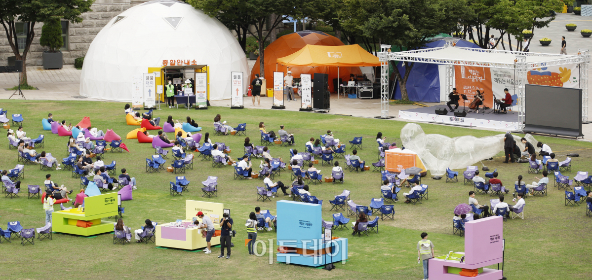 ▲서울 야외도서관 '책 읽는 서울광장'이 하반기 운영을 시작한 14일 오후 서울 중구 서울광장을 찾은 시민들이 '시네마틱 트리오의 클래식으로 듣는 영화음악' 공연을 관람하고 있다. 11월 12일까지 매주 목요일부터 일요일 운영되는 책 읽는 서울광장은 '음악과 책'을 주제로 운영된다. 개장 첫 주인 14~15일 점심 시간대에는 클래식·재즈 공연과 디즈니와 스튜디오 지브리의 애니메이션 오리지널 사운트 트랙(OST) 공연이 열린다. 조현호 기자 hyunho@