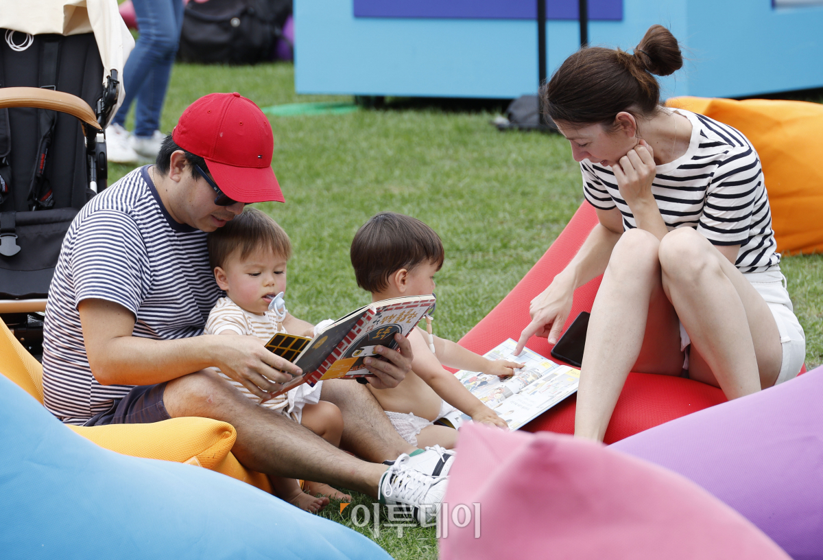 ▲서울 야외도서관 '책 읽는 서울광장'이 하반기 운영을 시작한 14일 오후 서울 중구 서울광장을 찾은 외국인 관광객이 아이들과 독서를 하고 있다. 11월 12일까지 매주 목요일부터 일요일 운영되는 책 읽는 서울광장은 '음악과 책'을 주제로 운영된다. 개장 첫 주인 14~15일 점심 시간대에는 클래식·재즈 공연과 디즈니와 스튜디오 지브리의 애니메이션 오리지널 사운트 트랙(OST) 공연이 열린다. 조현호 기자 hyunho@