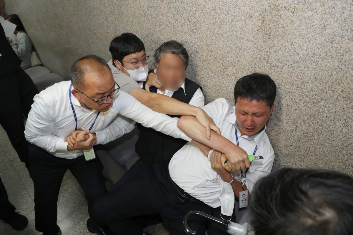 ▲단식 16일차를 맞은 15일  국회 더불어민주당 대표실 앞에서 신원미상의 한 남성이 15일 자해를 시도하다 국회 방호과 직원과 당직자들에 의해  제압되고 있다. 이 남성은 자신을 ‘이재명 지지자’라고 주장하는 것으로 알려졌다. 이재명 민주당 대표 지지자의 흉기난동은 전날에 이어 이번이 두 번째다. 신태현 기자 holjjak@