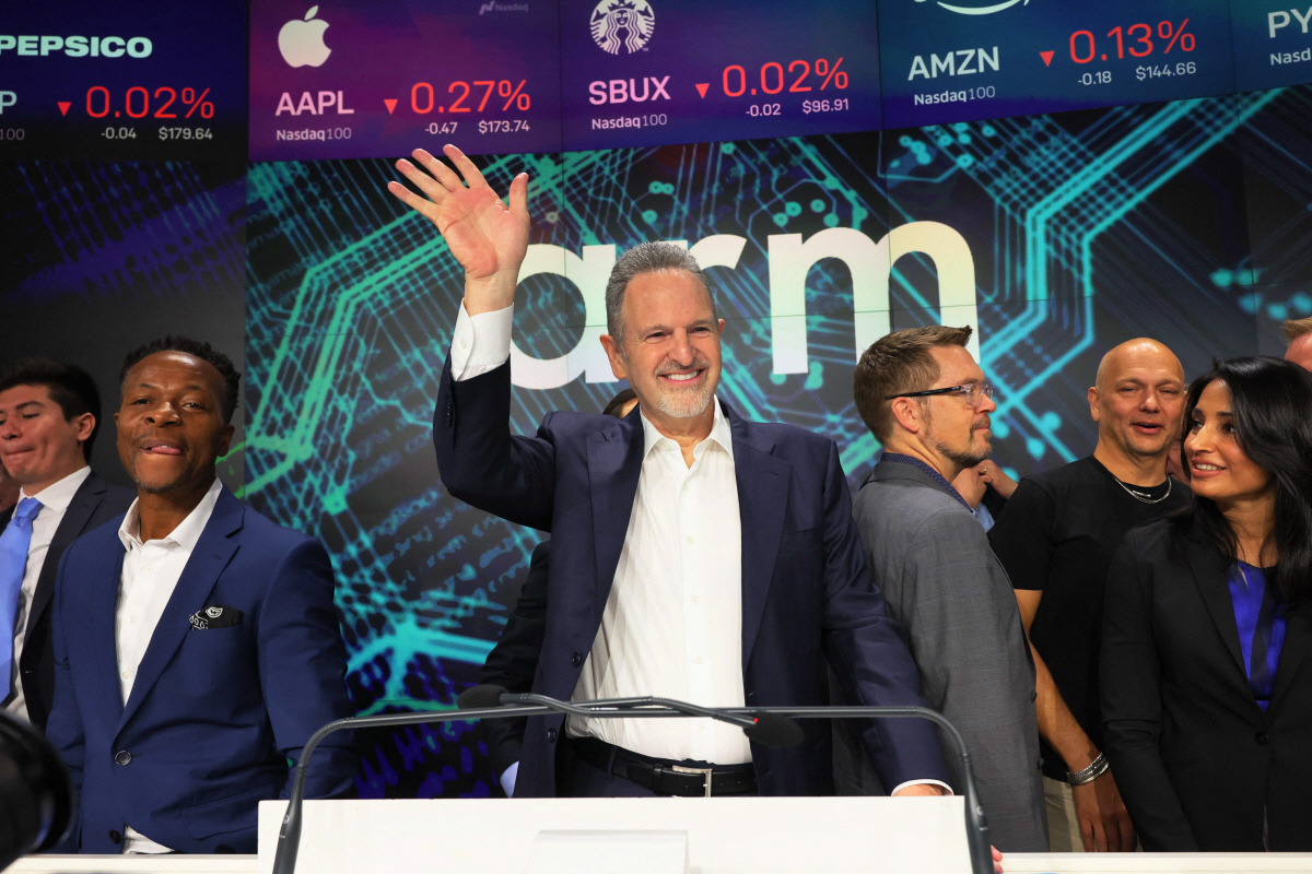 ▲ARM의 르네 하스(가운데) 최고경영자(CEO)가 14일(현지시간) 자사의 미국 나스닥거래소 상장을 축하하는 ‘오프닝 벨’ 행사에 참석하고 나서 행사가 끝난 뒤 손을 흔들고 있다. 뉴욕(미국)/AFP연합뉴스