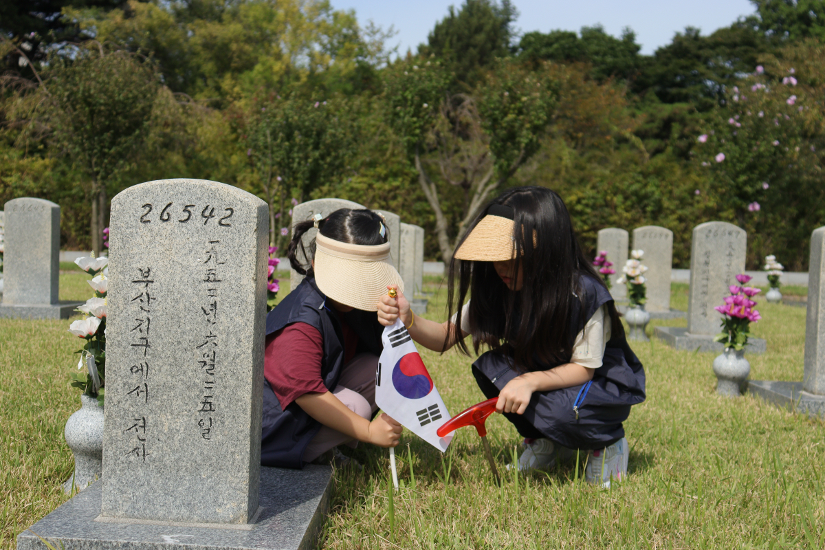 ▲LIG넥스원 직원 가족들이 묘역 정화 활동을 펼치고 있다. (사진제공=LIG넥스원)