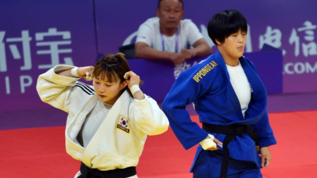 ▲유도 대표팀 한희주(왼쪽)가 25일 중국 저장성 항저우 샤오산 린푸 체육관에서 열린 2022 항저우 아시안게임 유도 여자 70㎏급 북한 문성희와 16강 경기에서 제자리로 이동하고 있다. 연합뉴스
