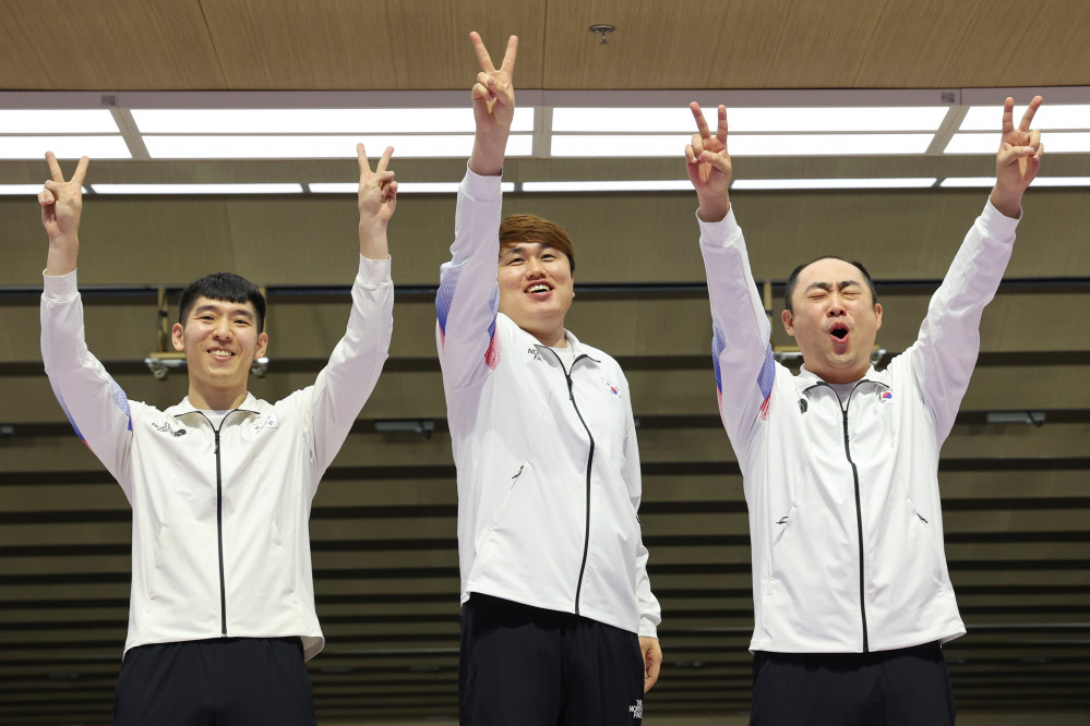 ▲26일 중국 항저우 푸양 인후 스포츠센터에서 열린 제19회 항저우 아시안게임 남자 10ｍ 러닝타깃 혼합 단체전에서 금메달을 딴 한국 곽용빈(왼쪽부터), 정유진, 하광철이 시상대에 올라 손을 들어 올려 보이고 있다.  (연합뉴스)