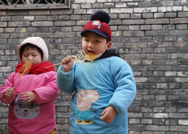 ▲중국 장쑤성 쉬이의 한 거리에서 아이들이 사탕을 먹고 있다. 쉬이(중국)/신화뉴시스
