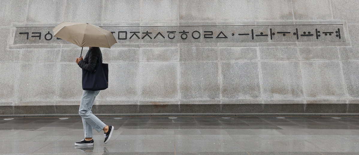 ▲서울 광화문광장에서 우산을 쓴 시민이 세종대왕 동상 근처를 지나가고 있다. (연합뉴스)