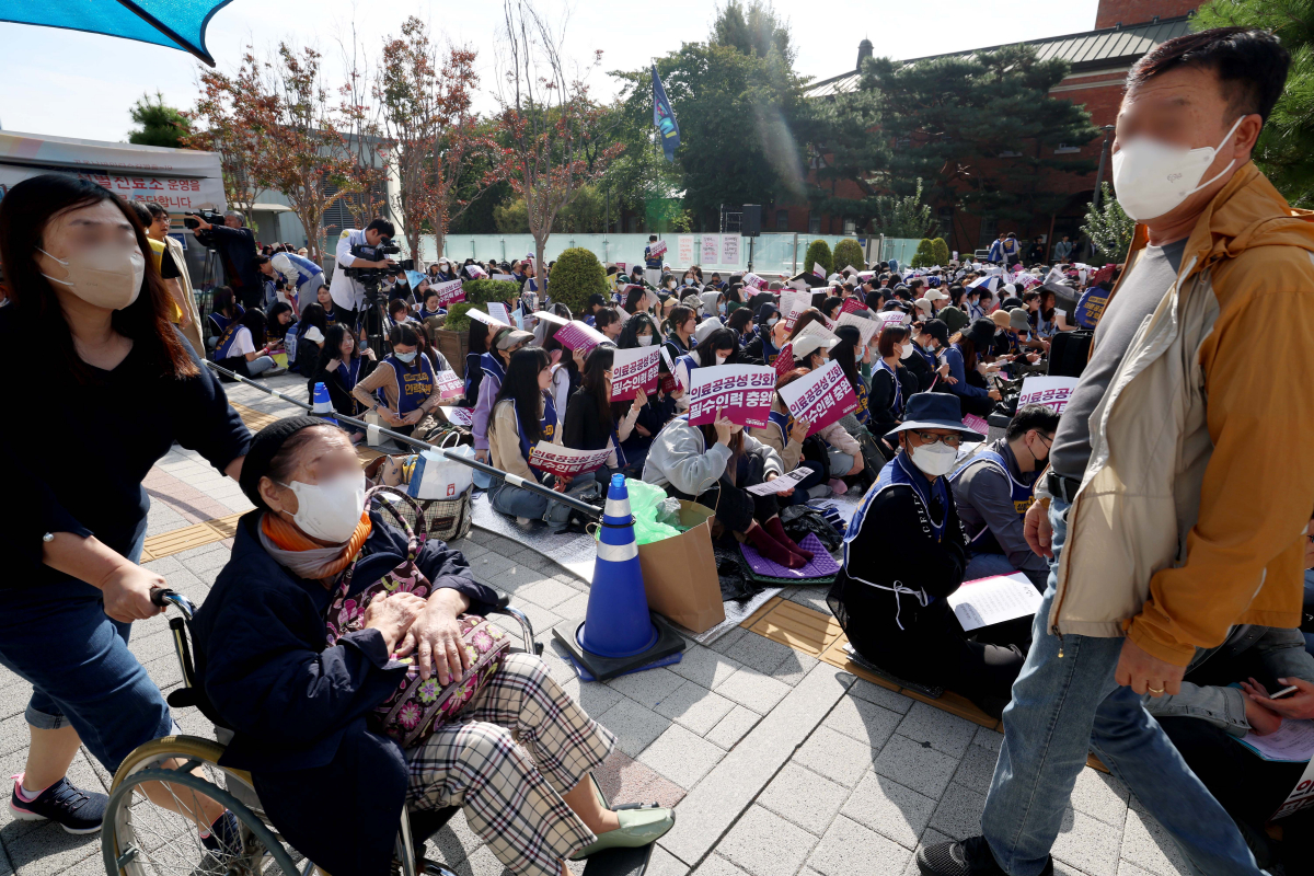 ▲민주노총 공공운수노조 의료연대본부 서울지역지부 서울대병원분회가 11일 서울 종로구 서울대병원에서 인력확충과 임금인상 등을 요구하며 총파업 출정식을 가졌다. 조합원 곁으로 시민들이 발걸음을 옮기고 있다. 신태현 기자 holjjak@