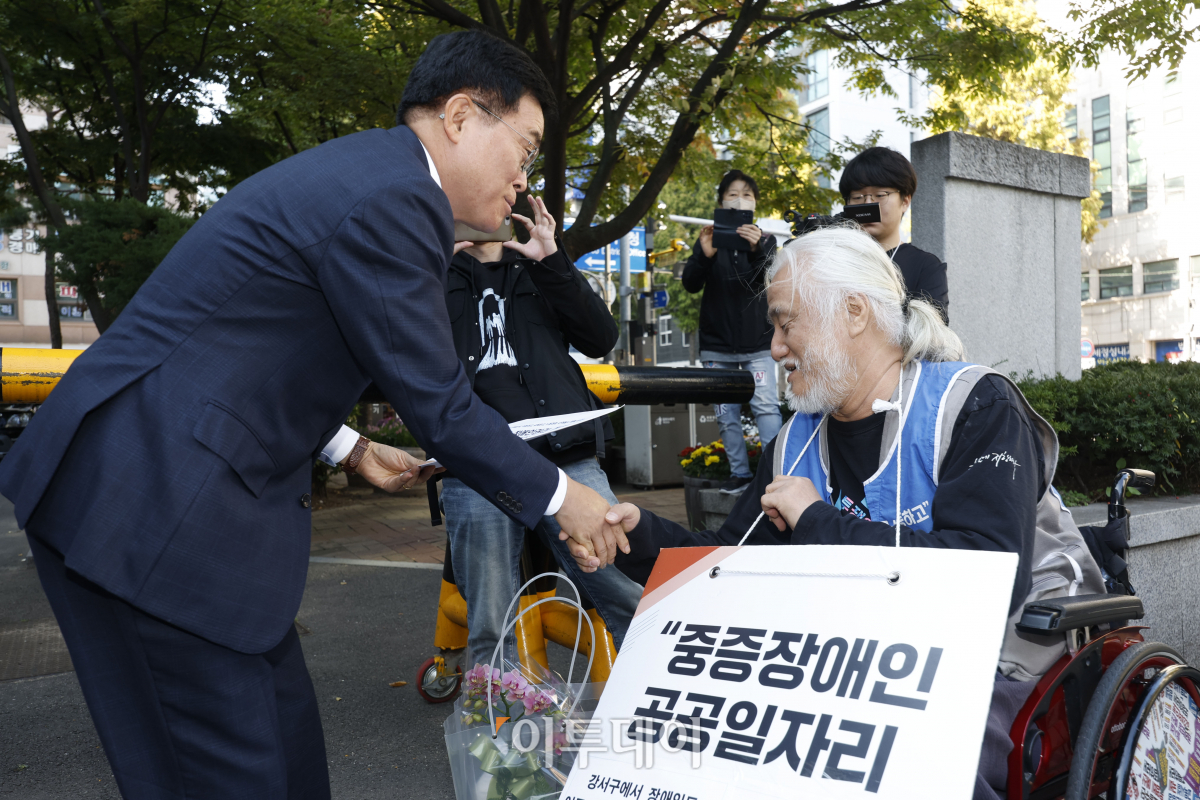 ▲진교훈 신임 강서구청장이 12일 서울 강서구청에 첫 출근하며 박경석 전국장애인차별철폐연대 대표와 대화를 하고 있다. 조현호 기자 hyunho@