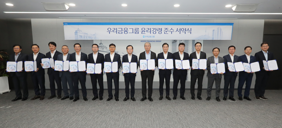 ▲임종룡(왼쪽서 아홉번째) 우리금융그룹 회장과 계열사 대표들이 20일 우리금융 본사에서 열린 '윤리강령 준수 서약식'에서 기념촬영을 하고 있다. (사진제공=우리금융그룹)