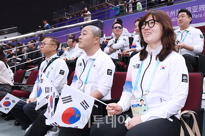 ▲장미란(오른쪽) 문체부 제2차관과 김진혁(가운데) 선수단장이 22일 중국 항저우 궁수 캐널 스포츠파크 체육관에서 열린 2022 항저우 장애인아시아경기대회에서 탁구 경기에 출전하는 대한민국 선수들을 응원하고 있다. 사진공동취재단