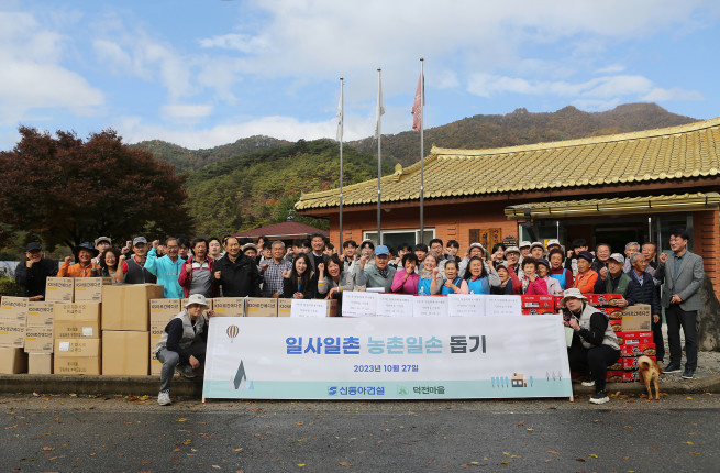 ▲27일 강원도 영월군 덕상2리 덕전마을을 찾아 일손돕기 활동을 한 신동아건설 임직원과 마을 주민들이 기념 촬영을 하고 있다. (사진제공=신동아건설)