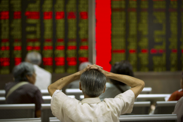 ▲중국 베이징의 한 증권사에서 한 투자자가 손을 머리에 얹고 전광판을 보고 있다. 베이징/AP뉴시스
