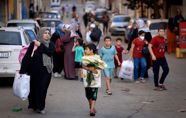 ▲13일(현지시간) 가자지구에서 팔레스타인 여성들과 어린이들이 짐을 챙겨 피신하고 있다. 가자지구(팔레스타인)/AFP연합뉴스

