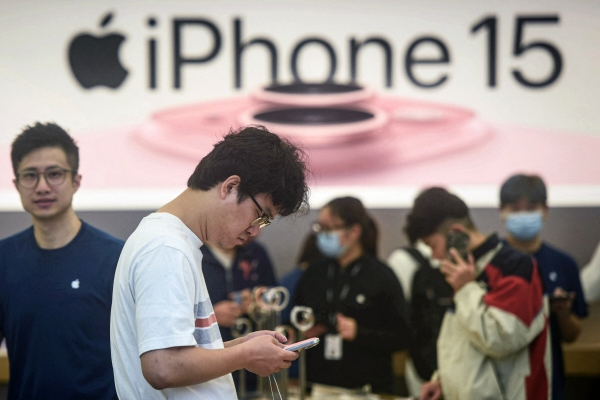 ▲중국 저장성 항저우의 애플스토어에서 9월 22일 한 남성이 아이폰15를 들여다보고 있다. 항저우(중국)/AFP연합뉴스 
