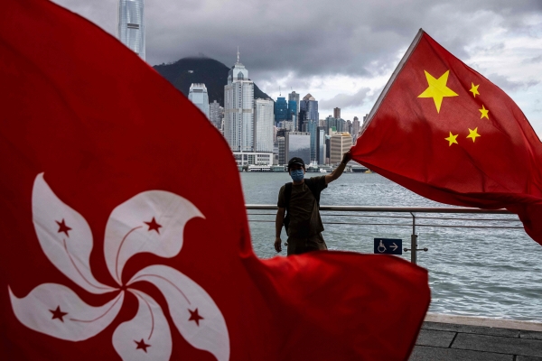 ▲홍콩에서 지난해 7월 1일 홍콩 국기 너머로 한 남성이 오성홍기를 들고 있다. 홍콩/AFP연합뉴스
