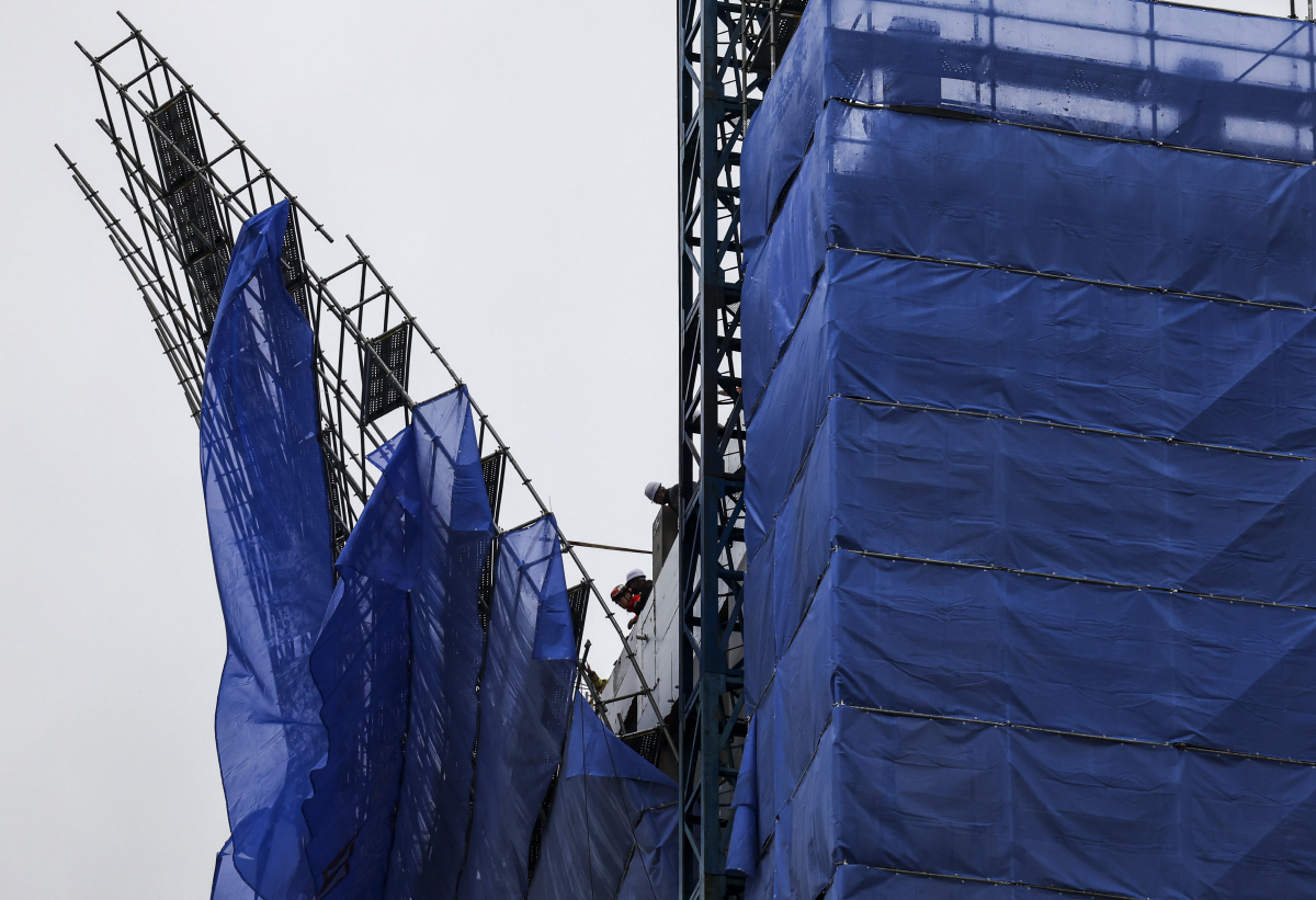 ▲6일 서울 마포구 만리재로 한 오피스텔 공사현장 외벽에 설치된 비계가 강풍으로 인해 넘어가 소방, 경찰, 마포구청 관계자들이 사고방지를 위한 로프를 설치하고 있다. (뉴시스)