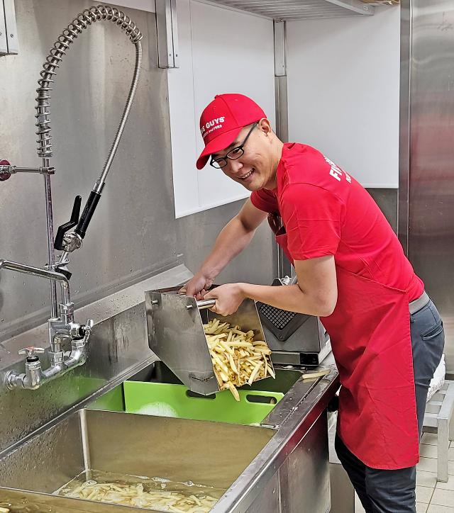 ▲ 4월 파이브가이즈 홍콩에서 현장 실습에 참여한 김동선 한화갤러리아 부사장이 감자튀김을 직접 만들고 있다. (사진제공=한화갤러리아 )