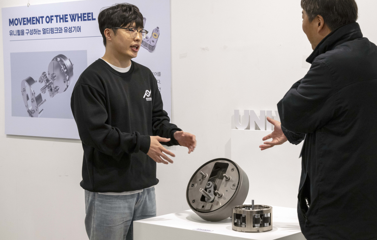 ▲현대차·기아 연구원(왼쪽)이 참가자(오른쪽)에게 유니휠 기술에 대해 설명하는 모습 (사진제공=현대자동차그룹)