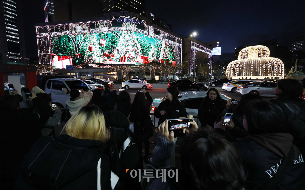 ▲성탄절을 한 달여 앞둔 28일 서울 중구 신세계백화점 본점에서 시민들이 외벽에 LED 조명으로 밝힌 미디어 파사드(Media Fasade) 크리스마스 영상을 핸드폰 카메라에 담고 있다. 신세계백화점 본점 외벽의 미디어 파사드는 375만 개의 LED 칩을 사용해 63x18m 크기의 거대한 스크린으로 탈바꿈했다. 지난해 글자를 새겼던 돌출부 발코니까지 모두 LED로 덮은 것이 특징이다. 9일 시작해 내년 1월 말까지 운영하는 미디어 파사드는 3분 가량의 크리스마스 영상이 매일 오후 5시 30분부터 10시 30분까지 반복 재생된다. 조현호 기자 hyunho@