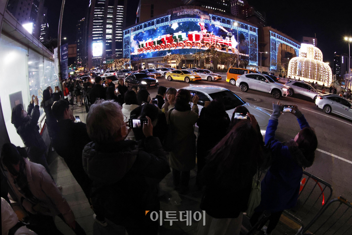 ▲성탄절을 한 달여 앞둔 28일 서울 중구 신세계백화점 본점에서 시민들이 외벽에 LED 조명으로 밝힌 미디어 파사드((Media Fasade) 크리스마스 영상을 핸드폰 카메라에 담고 있다. 신세계백화점 본점 외벽의 미디어 파사드는 375만 개의 LED 칩을 사용해 63x18m 크기의 거대한 스크린으로 탈바꿈했다. 지난해 글자를 새겼던 돌출부 발코니까지 모두 LED로 덮은 것이 특징이다. 9일 시작해 내년 1월 말까지 운영하는 미디어 파사드는 3분 가량의 크리스마스 영상이 매일 오후 5시 30분부터 10시 30분까지 반복 재생된다. 조현호 기자 hyunho@