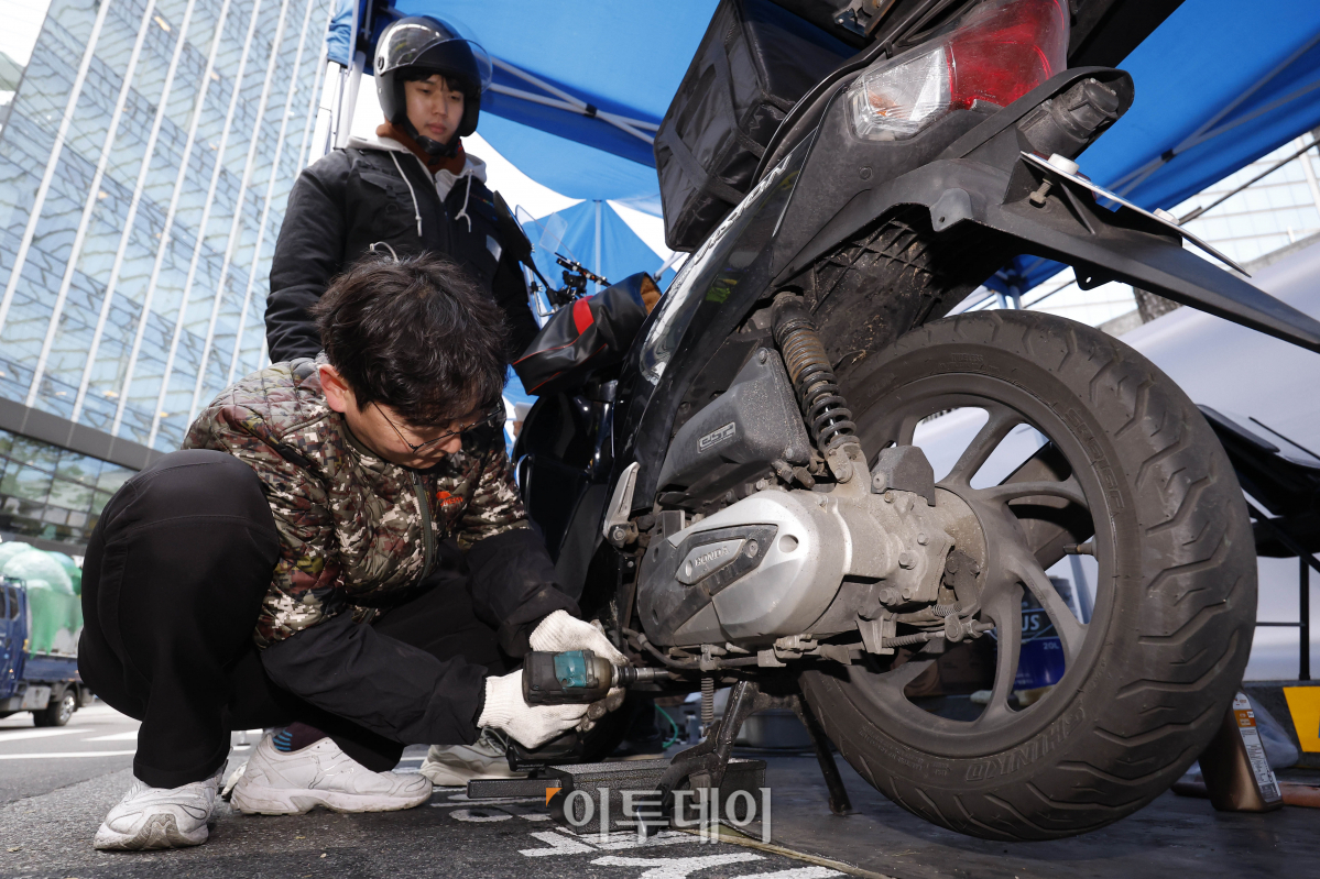 ▲29일 서울 강남구 이동노동자 쉼터 2호점 앞에서 열린 이륜차 무상점검 안전 캠페인에서 이동노동자들이 이륜차 무상점검을 받고 있다. 이날 강남구청과 쿠팡이츠서비스가 함께 진행한 이륜차 무상점검 캠페인에서는 사전 신청한 이동노동자 200명을 대상으로 한국오토바이협회 소속 정비사들이 이륜차 안전점검, 브레이크, 전조등 등 소모품 무상 교한해주고 쿠팡이츠서비스가 무상 제공한 헬멧 김서림 방지제, 스마트폰 터치 장갑 등 겨울철 안전용품을 제공한다. 캠페인은 이날부터 30일까지 이틀간 오전 10시부터 오후 5시까지 실시한다. 조현호 기자 hyunho@