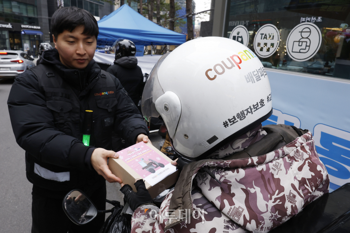 ▲29일 서울 강남구 이동노동자 쉼터 2호점 앞에서 열린 이륜차 무상점검 안전 캠페인에서 이동노동자들이 쿠팡이츠서비스 관계자에게 겨울철 안전용품을 전달받고 있다. 이날 강남구청과 쿠팡이츠서비스가 함께 진행한 이륜차 무상점검 캠페인에서는 사전 신청한 이동노동자 200명을 대상으로 한국오토바이협회 소속 정비사들이 이륜차 안전점검, 브레이크, 전조등 등 소모품 무상 교한해주고 쿠팡이츠서비스가 무상 제공한 헬멧 김서림 방지제, 스마트폰 터치 장갑 등 겨울철 안전용품을 제공한다. 캠페인은 이날부터 30일까지 이틀간 오전 10시부터 오후 5시까지 실시한다. 조현호 기자 hyunho@