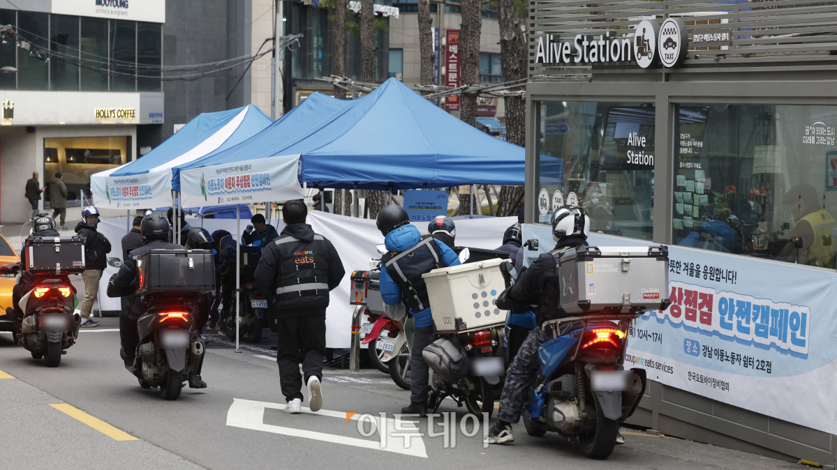 ▲29일 서울 강남구 이동노동자 쉼터 2호점 앞에서 열린 이륜차 무상점검 안전 캠페인에서 이동노동자들이 이륜차 무상점검을 받기 위해 대기하고 있다. 이날 강남구청과 쿠팡이츠서비스가 함께 진행한 이륜차 무상점검 캠페인에서는 사전 신청한 이동노동자 200명을 대상으로 한국오토바이협회 소속 정비사들이 이륜차 안전점검, 브레이크, 전조등 등 소모품 무상 교한해주고 쿠팡이츠서비스가 무상 제공한 헬멧 김서림 방지제, 스마트폰 터치 장갑 등 겨울철 안전용품을 제공한다. 캠페인은 이날부터 30일까지 이틀간 오전 10시부터 오후 5시까지 실시한다. 조현호 기자 hyunho@