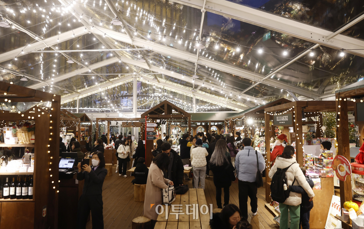 ▲29일 서울 송파구 롯데월드몰 앞 아레나 잔디 광장에 조성된 크리스마스마켓을 찾은 시민들이 마켓을 살펴보고 있다. 600평 규모의 부지에 약 7미터 높이의 대형 글라스 하우스를 마련한 크리스마스마켓은 PVC와 유리 등 투명한 소재로 천장과 벽을 마감해 야외의 느낌과 극대화 했다. 마켓 내에는 빈티지한 우드 톤의 가지 각색의 유럽식 상점들이 자리했다. 마켓에는 총 25브랜드가 참여해 2000여 종의 상품을 판매한다. 마켓은 12월 25일까지 매일 오전 10시 30분부터 오후 10시까지 운영한다. 조현호 기자 hyunho@