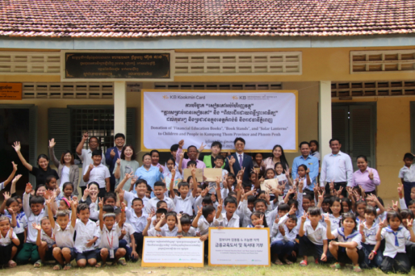 ▲7일 캄보디아 프놈펜에서 진행된 기부 물품 전달식에서 KB국민카드 현지법인 KB대한특수은행 임직원들과 운롱깐초등학교 아이들이 기념촬영을 하고 있다.