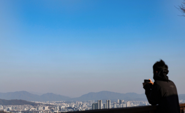 ▲맑은 날씨를 보인 11월 12일 서울 중구 남산공원에서 한 시민이 파란하늘을 촬영하고 있다. (뉴시스)