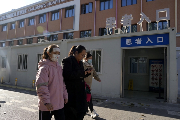 ▲중국 베이징에서 24일 어린이 환자와 보호자가 병원 앞을 지나가고 있다. 베이징/AP연합뉴스
