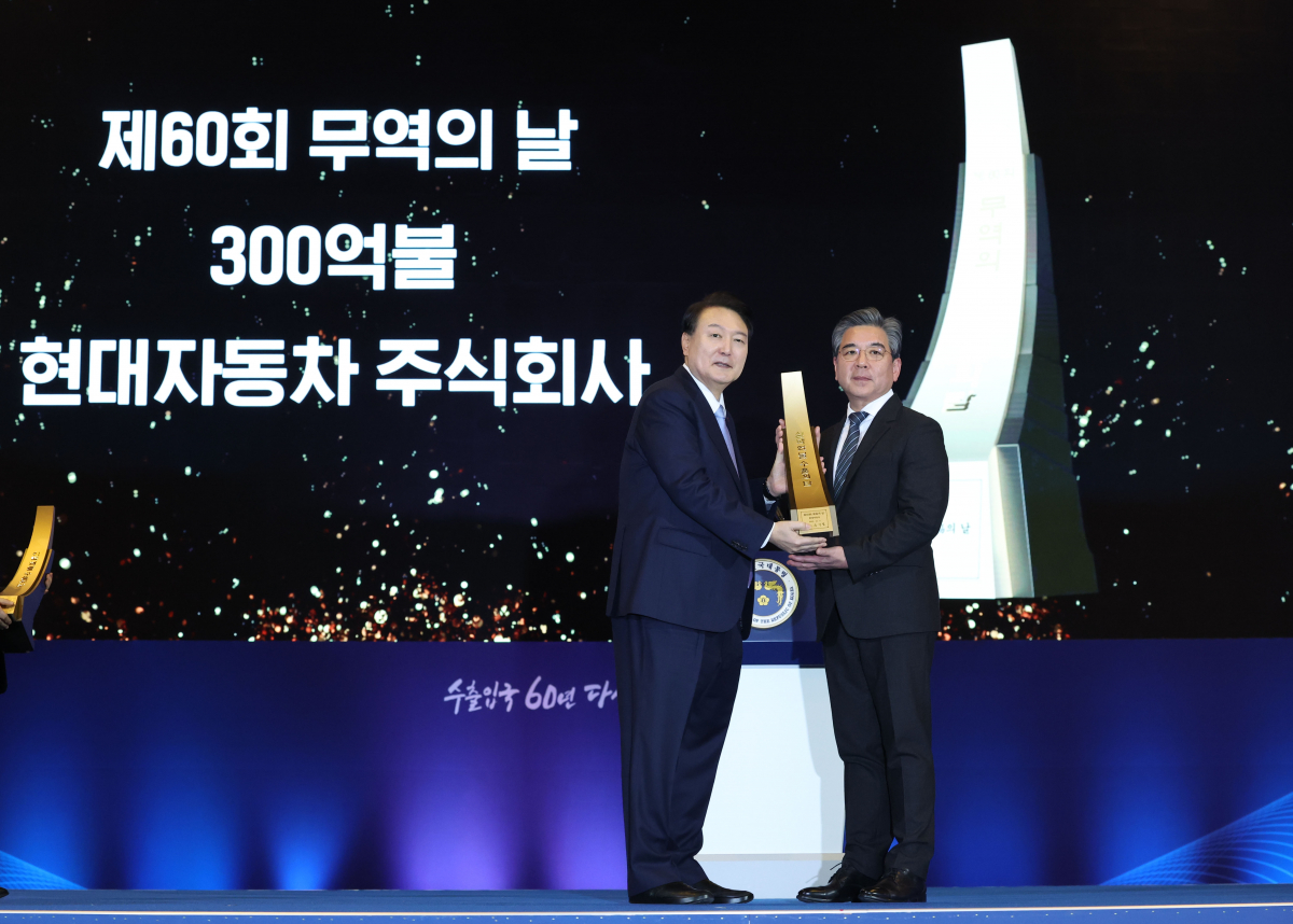 ▲윤석열 대통령이 5일 서울 강남구 코엑스에서 열린 제60회 무역의날 기념식에서 장재훈 현대자동차 대표이사에게 300억불 수출의 탑을 친수한 뒤 기념촬영을 하고 있다. (연합뉴스)