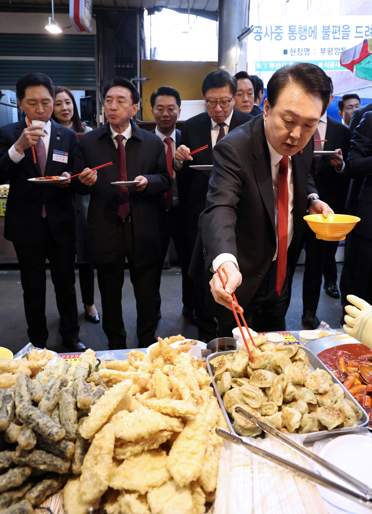 ▲윤석열 대통령이 6일 부산 중구 깡통시장에서 만두 등 분식을 시식하고 있다. (연합뉴스)