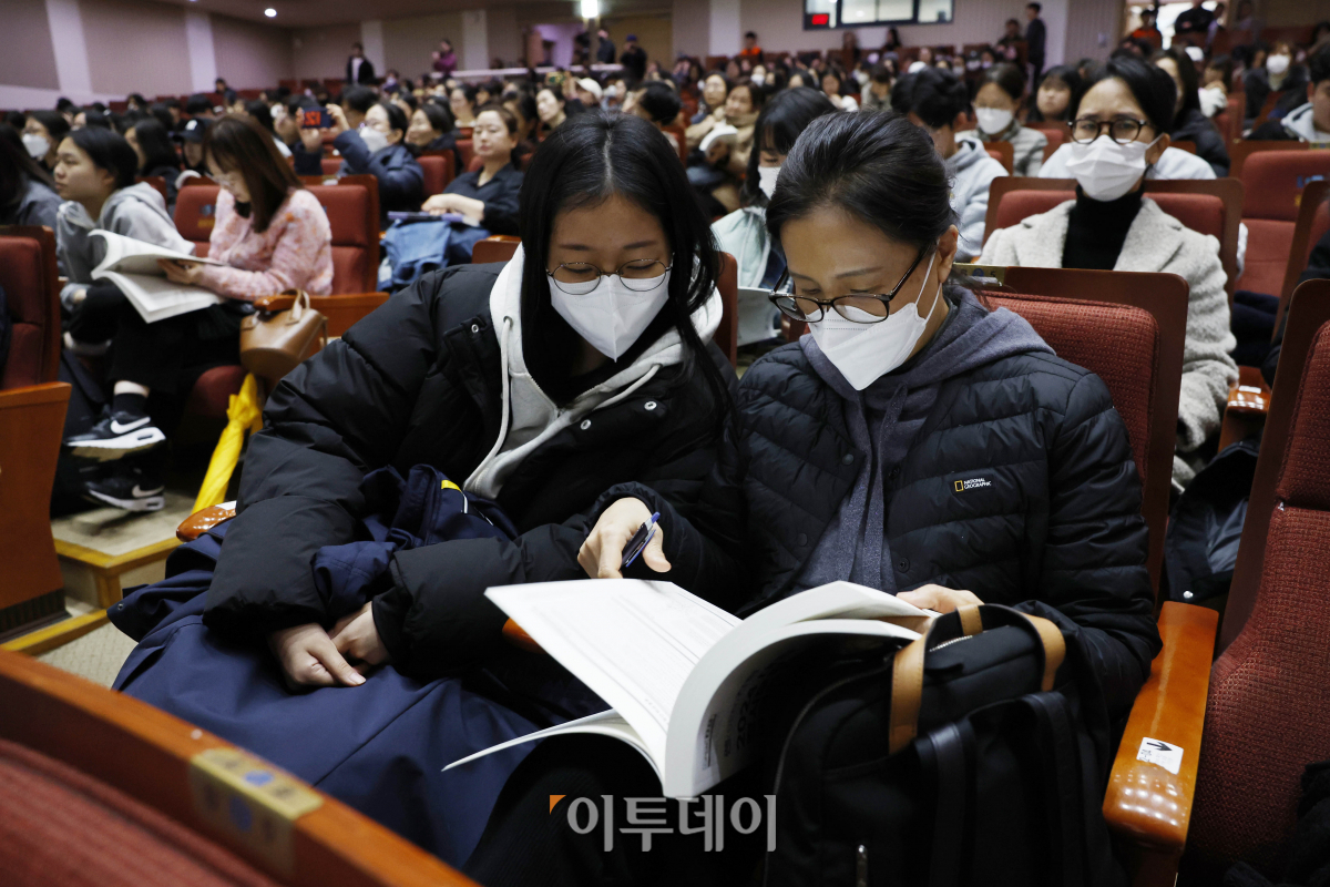 ▲11일 오후 서울 동작구 숭실대학교 한경직기념관에서 열린 2024 대입 정시모집 대비 학생·학부모 대상 대입 설명회에서 학생과 학부모들이 입시 자료집을 살펴보고 있다. 조현호 기자 hyunho@