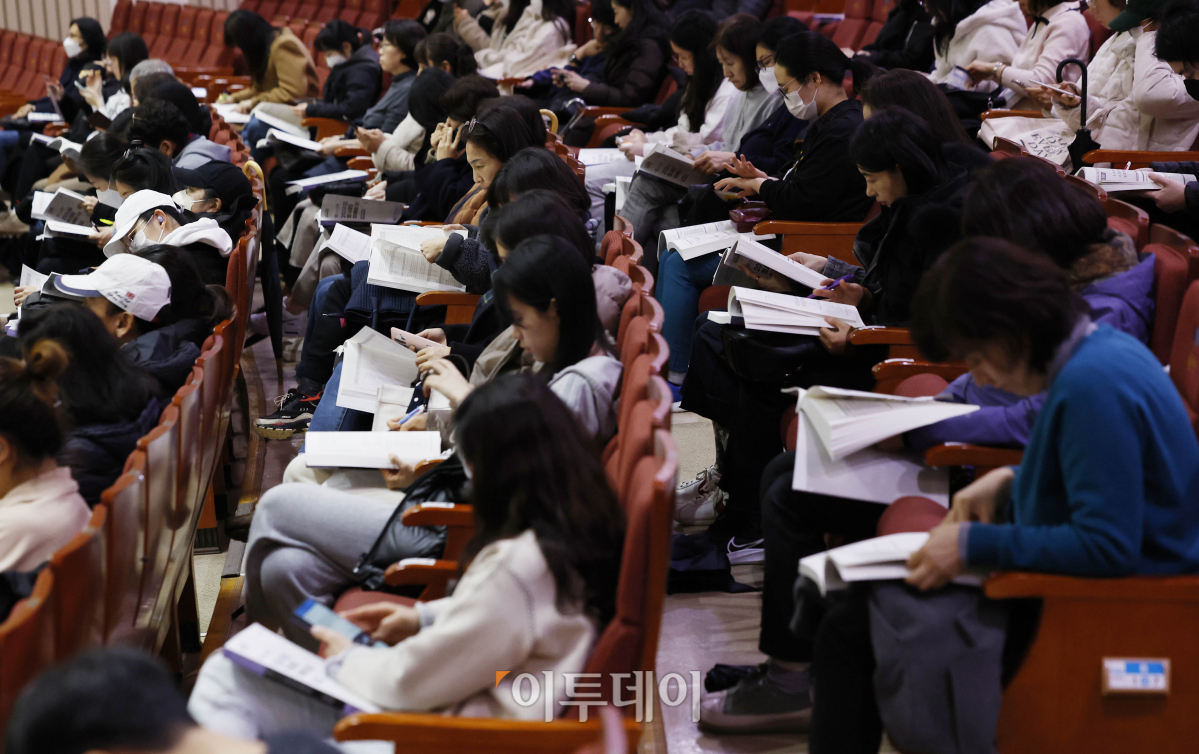 ▲11일 오후 서울 동작구 숭실대학교 한경직기념관에서 열린 2024 대입 정시모집 대비 학생·학부모 대상 대입 설명회에서 학생과 학부모들이 입시 자료집을 살펴보고 있다. 조현호 기자 hyunho@