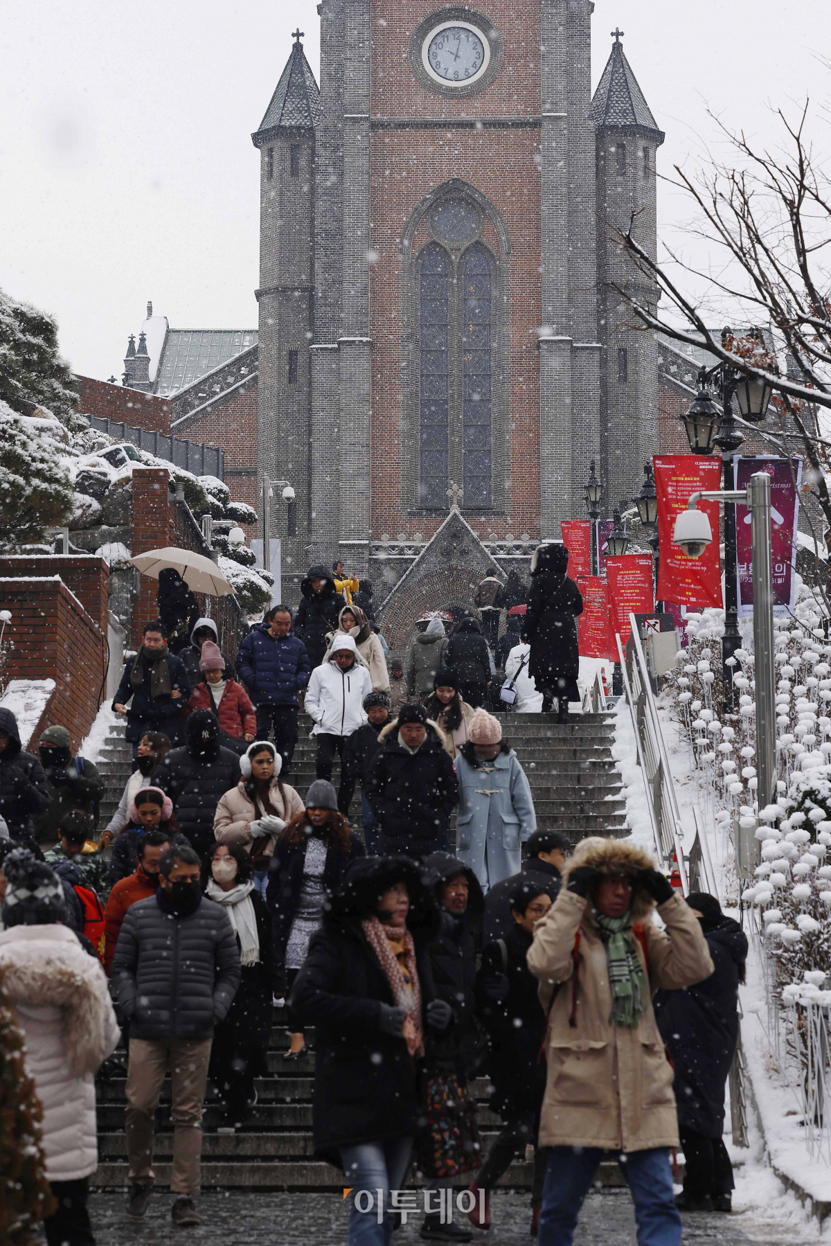 ▲서울에 눈이 내리며 2015년 이후 8년만에 화이트 크리스마스를 맞은 25일 서울 중구 명동성당에서 시민들이 눈을 피해 발걸음을 옮기고 있다. 조현호 기자 hyunho@