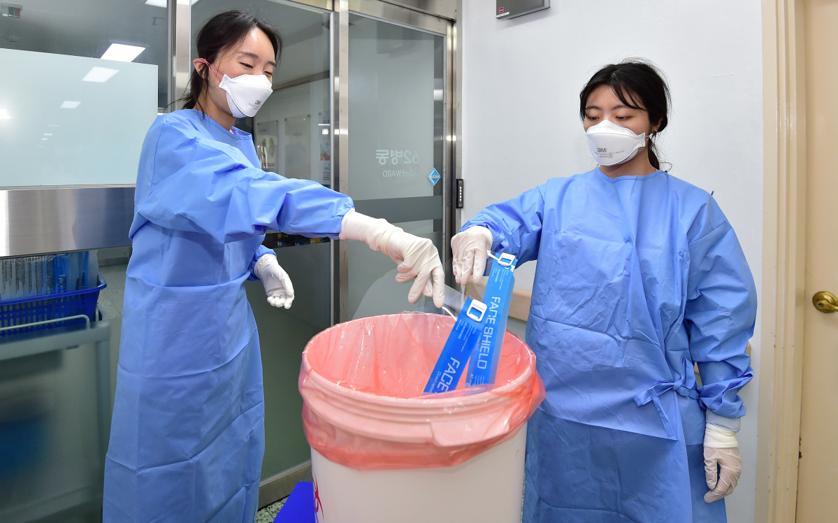 ▲코로나19 위기 경보 단계가 ‘심각'에서 ‘경계'로 하향 조정된 6월 1일 대구 중구 계명대학교 대구동산병원에서 코로나격리병동 간호사들이 근무교대 후 페이스쉴드를 의료폐기물 전용용기에 넣고 있다. (뉴시스)