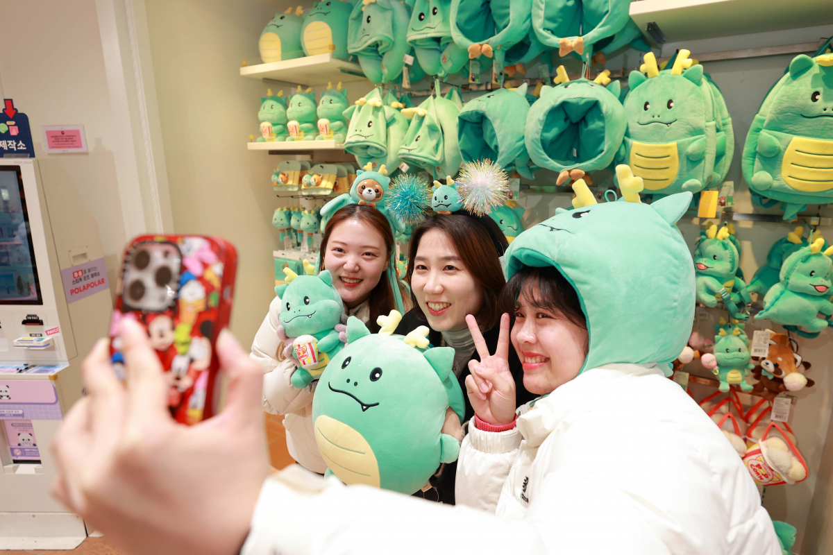 ▲시민들이 에버랜드 기프트샵에 진열된 용인특례시 공식마스코트 조아용과 함께 사진을 찍고있다. (용인시)