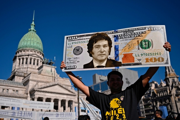 ▲아르헨티나 부에노스아이레스에서 10일(현지시간) 한 시민이 하비에르 밀레이 대통령 얼굴이 담긴 지폐 모형을 들고 있다. 부에노스아이레스/AFP연합뉴스
