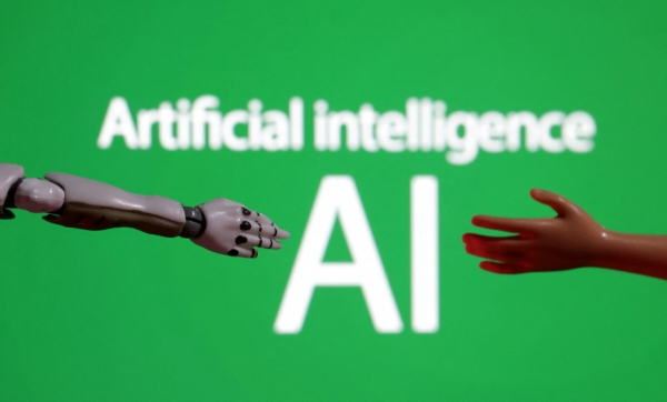 ▲인공지능(AI) 단어 앞에 로봇과 인간의 손이 보인다. 로이터연합뉴스
