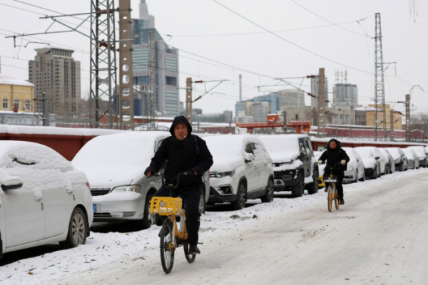 ▲15일(현지시간) 중국 베이징에서 시민들이 자전거를 타고 눈 덮힌 거리를 지나고 있다. (로이터/연합뉴스)