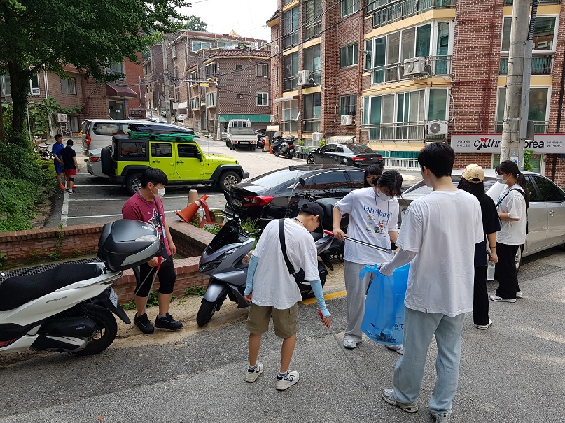 ▲ 지난해 여름 환경순찰 체험단 학생들이 쓰레기 무단투기 청소 봉사활동을 하고 있다. (자료제공=강북구)