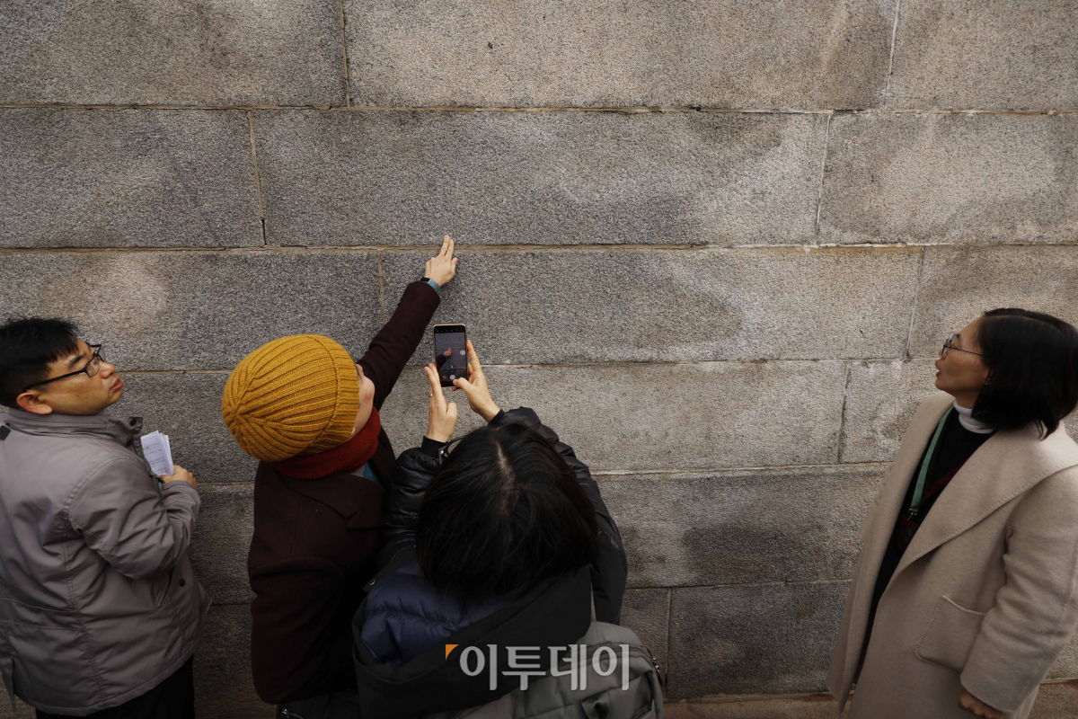 ▲4일 낙서 제거 작업을 마친 서울 종로구 경복궁 영추문 앞에서 시민들이 낙서가 제거된 담벼락을 살펴보고 있다. 조현호 기자 hyunho@