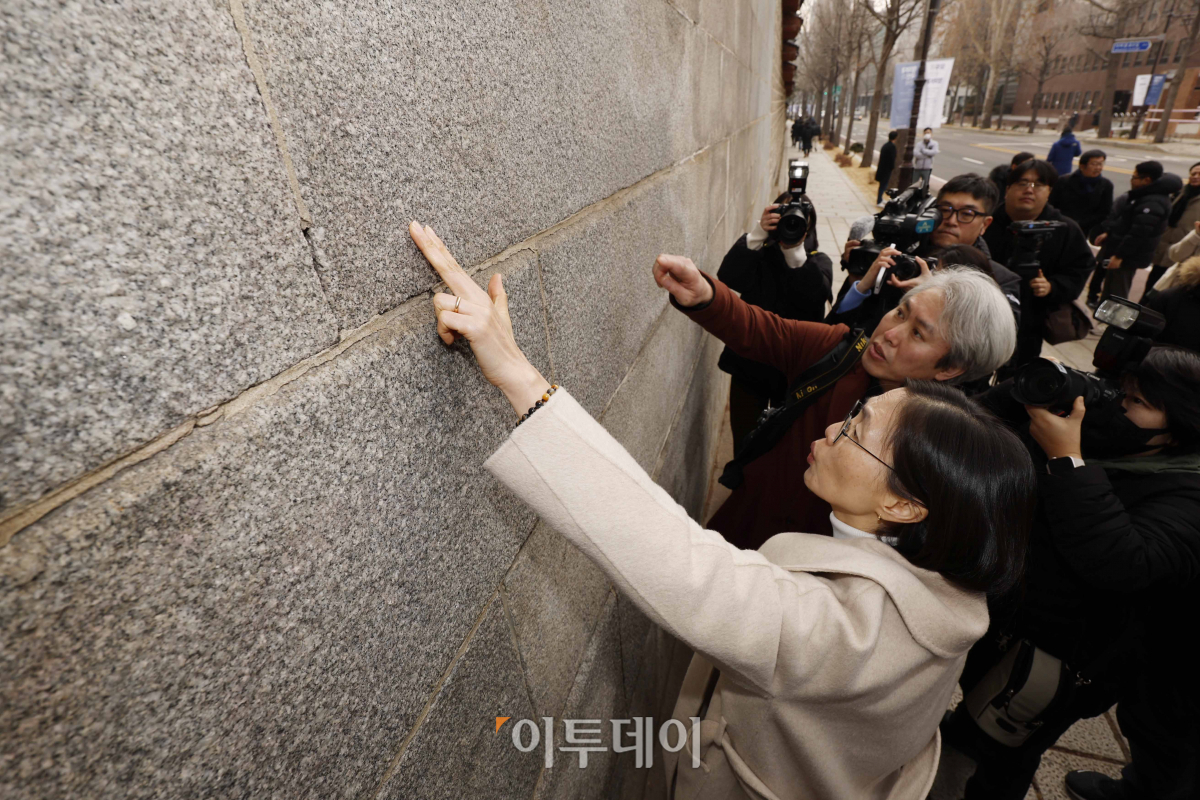 ▲4일 낙서 제거 작업을 마친 서울 종로구 경복궁 영추문 앞에서 문화재청 관계자가 담장에 희미하게 남아있는 낙서 자국을 가리키고 있다. 조현호 기자 hyunho@