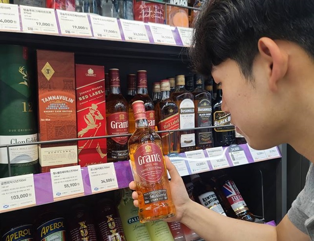 ▲소비자가 편의점 CU에서 위스키를 살펴보고 있다. (사진제공=BGF리테일)